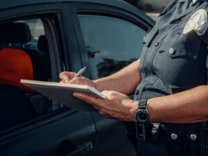 A police officer issues a citation to a motorist.
